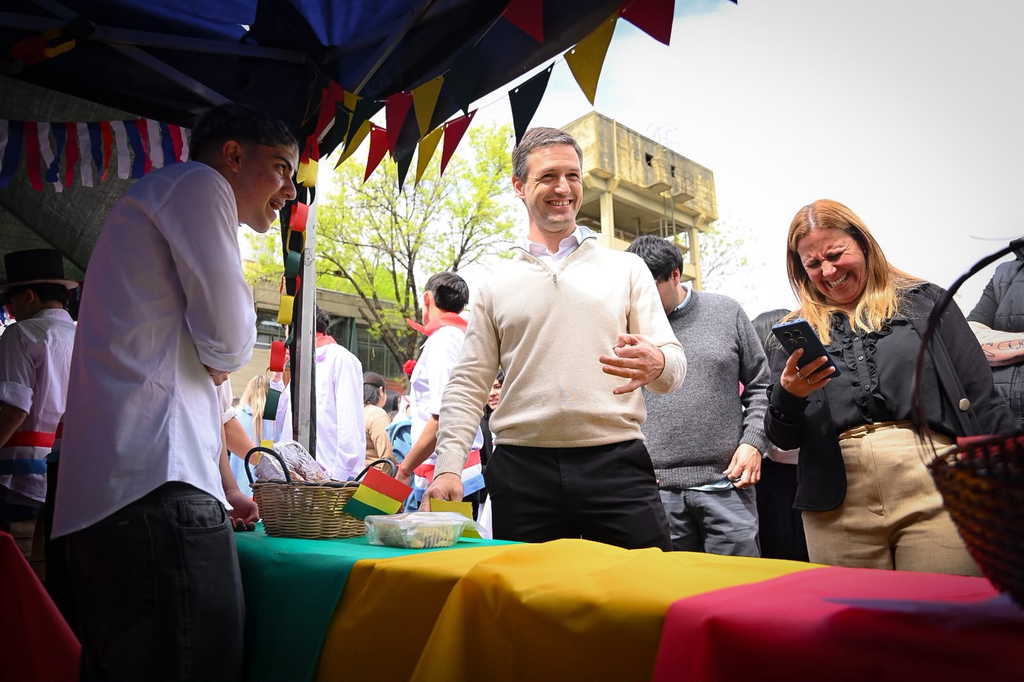 EMOCIONANTE | La Secundaria N° 2 celebró la 11° edición de la Feria de las Colectividades: Un viaje al corazón de nuestras raíces 5 El intendente Nicolás Mantegazza conversando con alumnos en el stand de Bolivia decorado con banderas y artesanías.