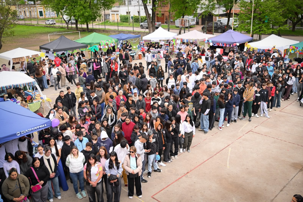 Vista panorámica del patio de la Escuela Secundaria 2 colmado de estudiantes y familias frente a los stands de la Feria de las Colectividades.