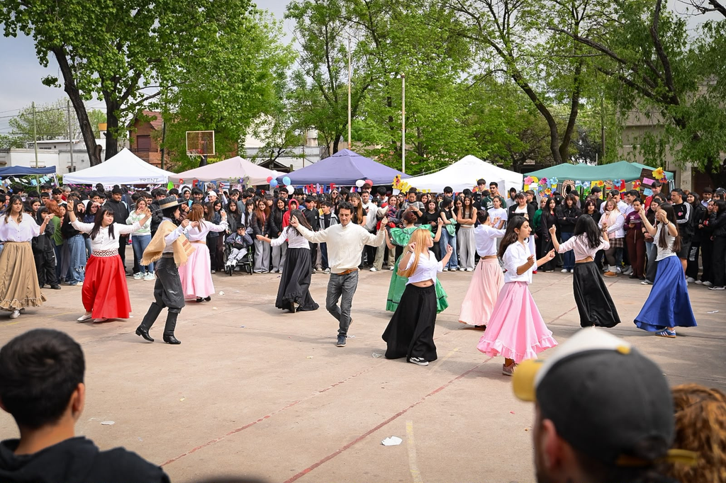 EMOCIONANTE | La Secundaria N° 2 celebró la 11° edición de la Feria de las Colectividades: Un viaje al corazón de nuestras raíces 6 Parejas de estudiantes de secundaria realizando bailes típicos y danzas folclóricas con vestidos tradicionales en el patio escolar.