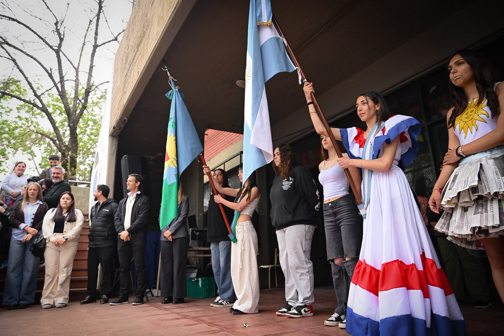 EMOCIONANTE | La Secundaria N° 2 celebró la 11° edición de la Feria de las Colectividades: Un viaje al corazón de nuestras raíces 3 Alumnas de la Escuela Secundaria 2 como abanderadas con la bandera argentina y bonaerense luciendo trajes tradicionales en el acto inaugural.
