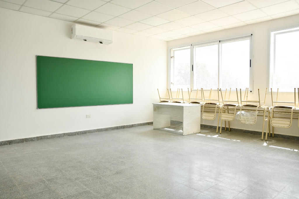 Aula equipada con pizarrón, bancos y climatización en la nueva Escuela Secundaria 11