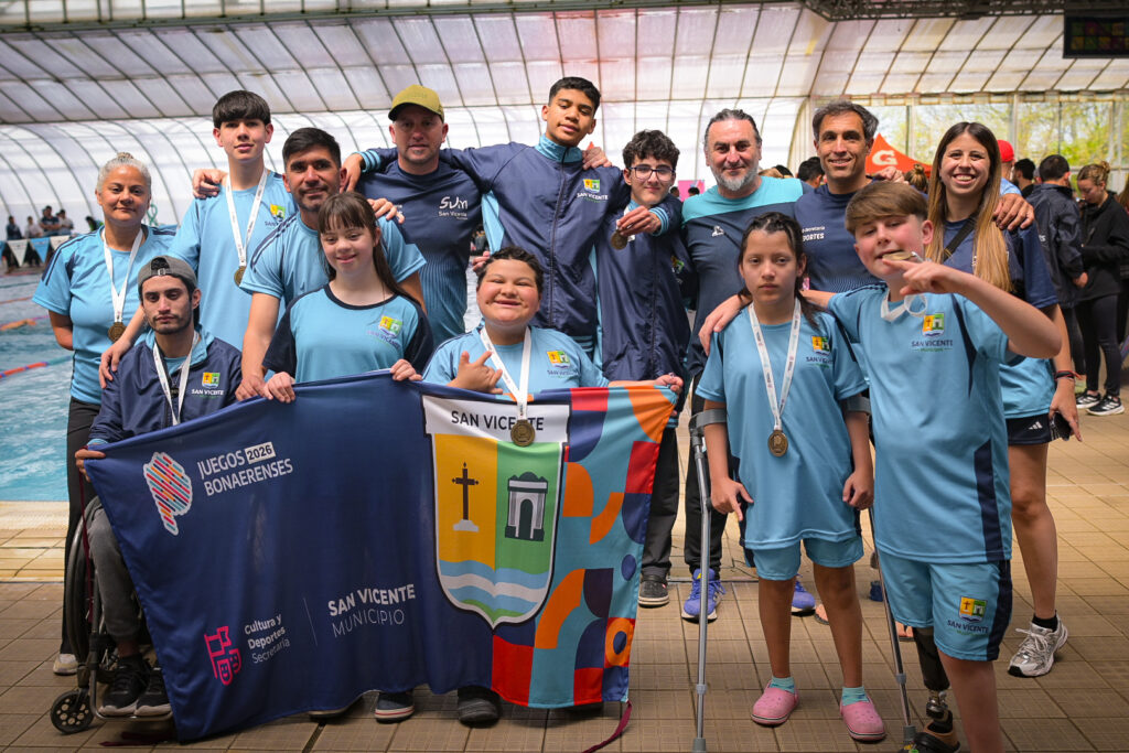 Equipo de natación y atletas PCD de San Vicente festejando con medallas y bandera municipal en el natatorio de Mar del Plata Juegos Bonaerenses 2026.